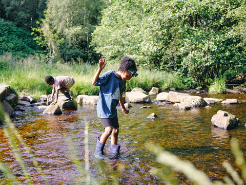 UK, Children Playing In Shallow Creek