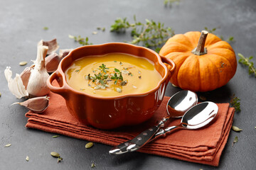 Pumpkin soup with thyme and pumpkin seeds on black background - Powered by Adobe