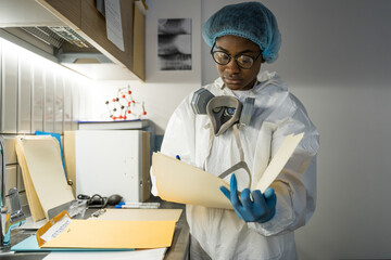 Fototapeta premium Doctor reading documents after hard day with at the isolation unit