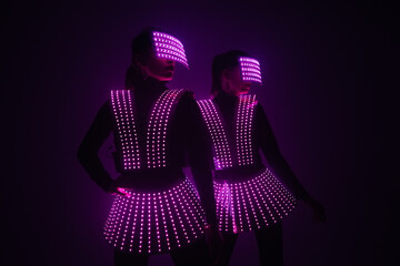 Two sexy disco dancers move in UV costumes. Parties and dances.