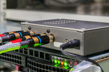 The AV cables are connected to a digital amplifier. The digital signal converter is in the rack. The multimedia equipment works in the server room.
