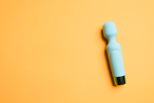 A sex toy. Blue vibrator for women on a yellow background. Useful for adults, sex shop