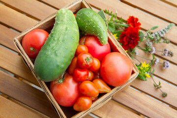 Homegrown vegetables in a basket, on a wooden table - a rural scene