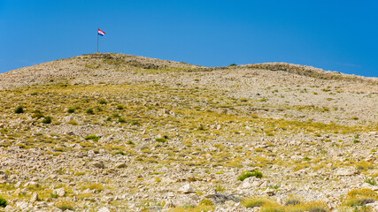 a stony hill with the croatian flag
