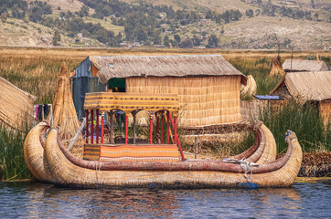 Boats and houses made of floating reed moored at Uros Islands in Titicaca Lake, Puno, Peru 