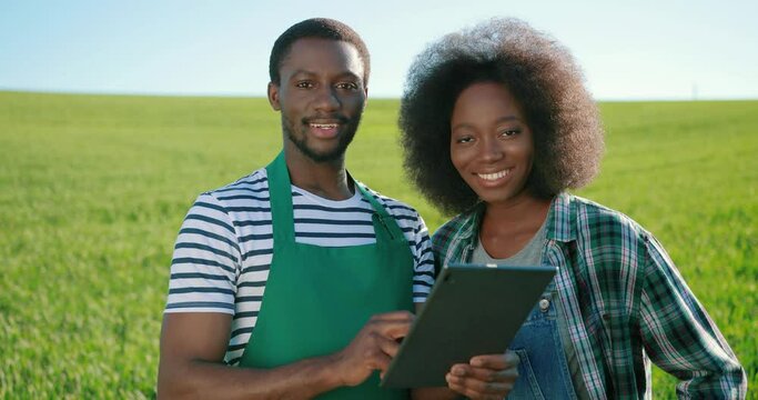 Male and female multiracial engineers using digital tablet while inspecting greenhouse organic farm business construction. Multi-sex farmers. Man and woman. Agronomy concept
