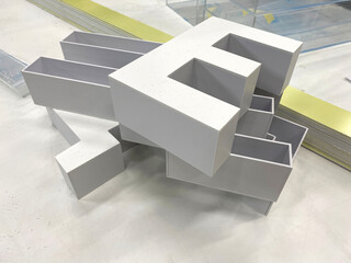 Three-dimensional letters made of PVC plastic are lying on the table. Production of outdoor and interior advertising.