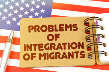On the US flag lies a notebook with the inscription - problems of integration of migrants