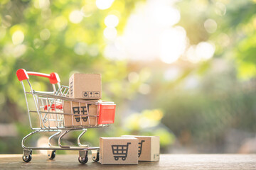 Shopping concept - Shopping cart or trolley and Paper cartons or parcel with a shopping cart logo...