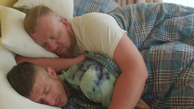 Man sleeping in an embrace in bed. LGBT love. Gender similarities and differences in casual sex acceptance among gay men. 