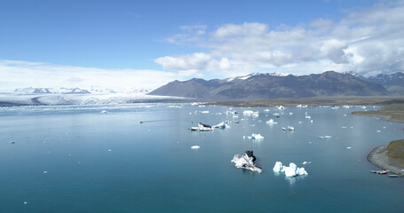 Aerial view over Glacier lagoon in Europe Iceland 
Melting icebergs with snowy mountains  Concept of global warming, February 2021
