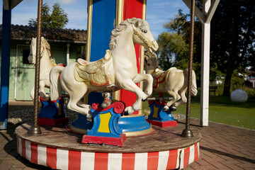 Closeup of white horse of merry-go-round carousel at the park on a sunny day