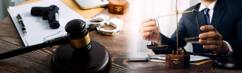 Justice and law concept.Male judge in a courtroom with the gavel, working with, computer and docking keyboard, eyeglasses, on table in morning light