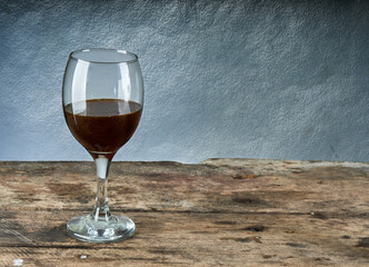 glass of red wine on vintage wooden table, copy space. horizontal and wall in the background