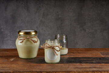 spa composition on wooden table and grey background. cosmetic products and burning candle. horizontal