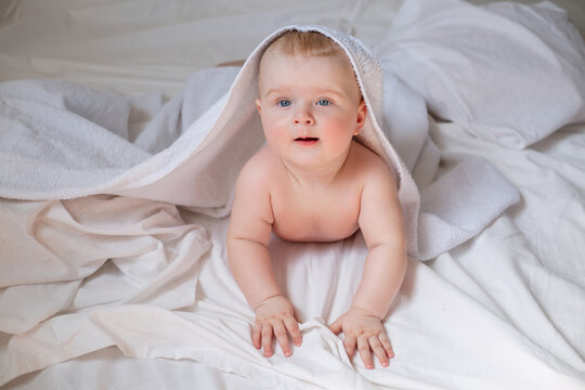 a cute baby is lying in diapers in a bed with white cotton bed linen. High quality photo