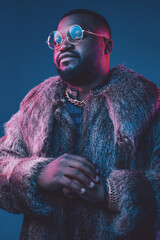 Confident fashion black man with fur coat and glasses