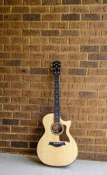 New Taylor Guitar On Brick Wall