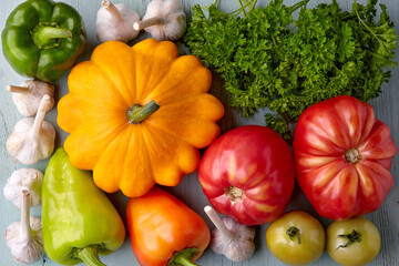 Ripe vegetables and herbs from the garden on a wooden table