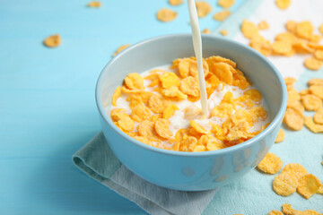 Crispy cornflakes with milk for breakfast on a colored background close-up.