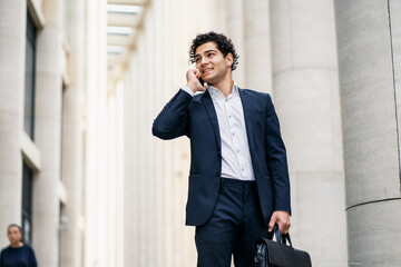 A male entrepreneur goes to work. A businessman trader responds to a client via mobile...