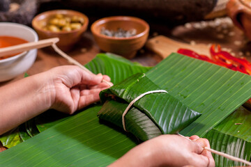 Hands making Guatemalan tamales.