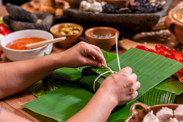 Hands making Guatemalan tamales. - obrazy, fototapety, plakaty