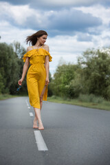 Young woman walking alone in the middle of the road.