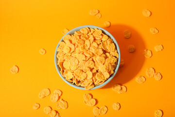Delicious cornflakes in a plate against colored background. 