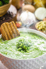Creamy organic broccoli soup served in winter in recycled bowl, vegan food