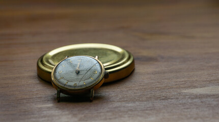 old gold watch on a wooden surface