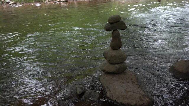 A roack cairn on the shore of a peacful river