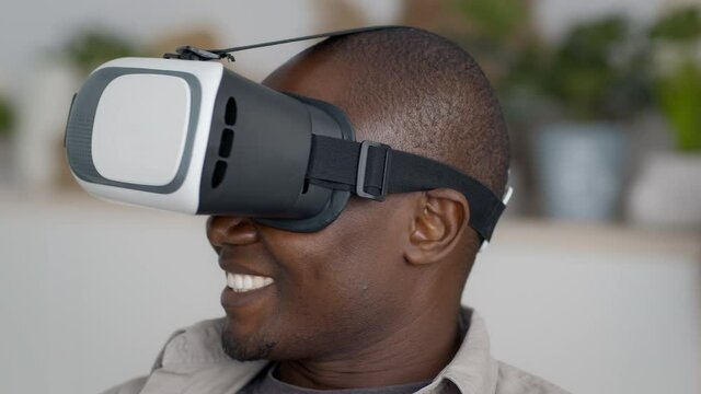 Excited Black Man Wearing VR Glasses Experiencing Virtual Reality Indoors