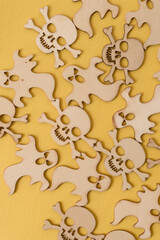 halloween themed wooden shapes (scary monsters and skull and crossbones) on a yellow background
