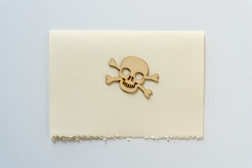 isolated retro halloween wooden shape (skull and crossbones) on a piece of ivory paper with space