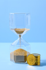 Hourglass and coins time is money concept