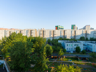 Summer evening in a residential area of a Russian city. Panel nine-story buildings against the background of a clear sky