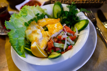Delicious fried halloumi cheese served with salad of vegetables and greens and lemon. Traditional Turkish cuisine