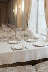 Beautifully set tables with glasses and plates in the restaurant 