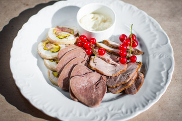 Cold appetizer with chopped beef tongue, currants and white sauce. View from above 