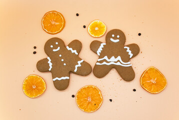 Christmas homemade gingerbread cookies with slices of oranges on light orange background 