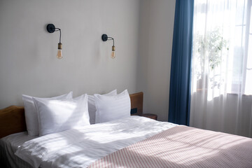 Bed in bedroom lit by sunlight