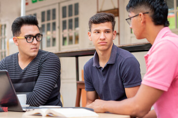 three bored students in an open-air latin coffee shop. concept of premises, students and latin business.