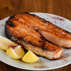 Slice of salmon red fish with lemon, on a white plate 