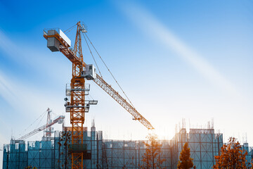 Crane lifting concrete mixer container against blue sky
