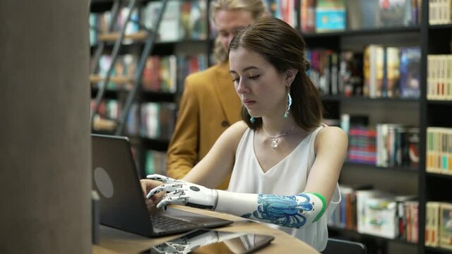 Girl and her boyfriend are working on laptop Bionics Cybernetic Robotic-arm Hand prosthesis