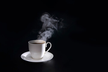 hot coffee with smoke in white cup isolated on black background