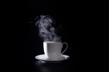 hot coffee with smoke in white cup isolated on black background