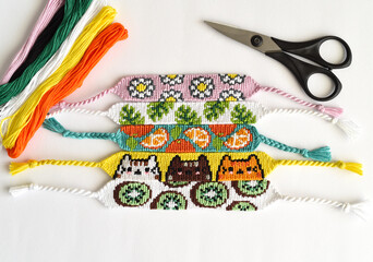 Woven DIY friendship bracelets handmade of embroidery floss with knots, alpha patterns