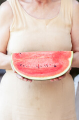 Woman holding slice of watermelon